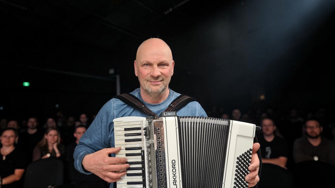 Musiker spielt das Elakkord auf der Bühne